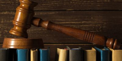 Gavel With Books On Old Wooden Desk